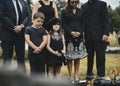 Sad grandkids standing by the grave