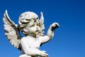 Sad guardian angel sculpture with open long wings across the frame desaturated against a bright white sky Royalty Free Stock Photo