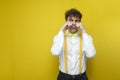 sad guy in festive outfit is crying and looking away at copy space, unhappy nerd student in shirt with bow tie Royalty Free Stock Photo