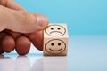 Sad And Happy Face Wooden Block Holding By Person`s Hand