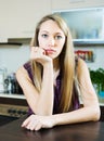 Sad houswife sitting at kitchen