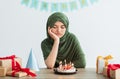 Sad Indian teen girl in hijab having dull birthday party, feeling bored, celebrating holiday alone during covid Royalty Free Stock Photo