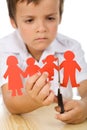 Sad kid cutting his paper people family Royalty Free Stock Photo