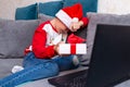 Sad kid meets Christmas through a video call with friends during pandemic coronavirus and shows gift box Royalty Free Stock Photo