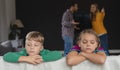 Sad kids leaning on sofa while parents arguing in background Royalty Free Stock Photo