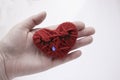 Sad knitted heart on the palm. The concept of separation of people, finished relationships, sadness