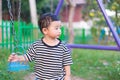 Sad little Asian kid at the playground under the sunlight in sum