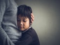 Sad little boy being hugged by his mother at home. Royalty Free Stock Photo