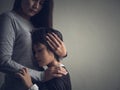 Sad little boy being hugged by his mother at home. Royalty Free Stock Photo