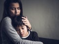 Sad little boy being hugged by his mother at home. Royalty Free Stock Photo