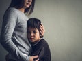 Sad little boy being hugged by his mother at home. Royalty Free Stock Photo