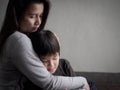 Sad little boy being hugged by his mother at home Royalty Free Stock Photo