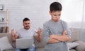Sad little boy offended at dad, angry father with laptop Royalty Free Stock Photo