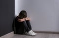 Sad little boy sitting on floor indoors Royalty Free Stock Photo