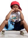 Sad little boy sitting on his skateboard Royalty Free Stock Photo