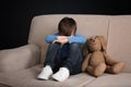 Sad little boy with toy sitting on couch Royalty Free Stock Photo