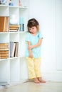 A sad little delinquent girl stands punished in the corner. Wines and punishment of children Royalty Free Stock Photo