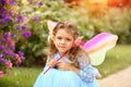 Sad little elf girl in a blue dress with wings in the park. Summer Royalty Free Stock Photo