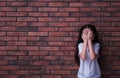 Sad little girl closing eyes with hands near wall, space for text. Child in danger Royalty Free Stock Photo