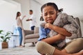 Sad, little girl and crying from parent fight, argument or divorce hugging teddy at home. Unhappy young child in Royalty Free Stock Photo