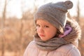 Sad little girl in a hat and a scarf on a walk in the autumn park Royalty Free Stock Photo