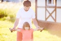 Sad little girl and her father lifting dumbbells outdoors