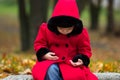 Sad little girl looking at her hands in autumn park Royalty Free Stock Photo