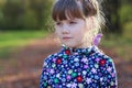 Sad little girl looks away in sunny green park Royalty Free Stock Photo