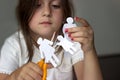 Sad little girl with paper family and scissors; divorce or family problems concept Royalty Free Stock Photo