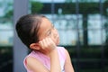 Sad little girl with posture her hand on cheek and looking out