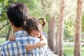 Sad little girl resting on her father's shoulder