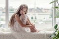 Sad little girl sits alone front of the window Royalty Free Stock Photo