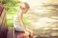 Sad little girl sitting on bench in the park Royalty Free Stock Photo