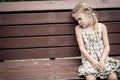 Sad little girl sitting on bench in the park Royalty Free Stock Photo