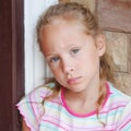 Sad little girl sitting near a door Royalty Free Stock Photo