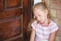 Sad little girl sitting near a door Royalty Free Stock Photo