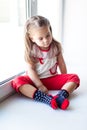 Sad little girl sitting near the window Royalty Free Stock Photo