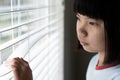 Sad little girl standing near the window Royalty Free Stock Photo