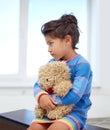 Sad little girl with teddy bear toy at home Royalty Free Stock Photo