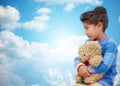 Sad little girl with teddy bear toy over blue sky Royalty Free Stock Photo