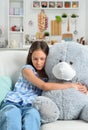 Sad little girl with toy bear in facial mask Royalty Free Stock Photo