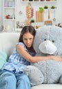 Sad little girl with toy bear in facial mask Royalty Free Stock Photo