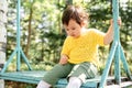 Sad little infant girl sitting on the swing Royalty Free Stock Photo