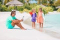 Sad little kids waiting for their dad working with laptop to swim and have fun on the beach Royalty Free Stock Photo