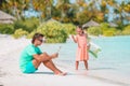 Sad little kids waiting for their dad working with laptop to swim and have fun on the beach Royalty Free Stock Photo