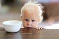 Sad Little One Year Old Baby Girl with Empty Cereal Bowl Royalty Free Stock Photo