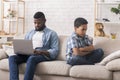 Sad little son offended to father busy with laptop at home Royalty Free Stock Photo