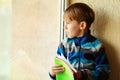 Sad little student holding notebooks. Schoolboy looking to window. Home education during world pandemic. Back to school Royalty Free Stock Photo