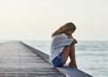 Sad lonely beautiful woman sitting on the pier Royalty Free Stock Photo