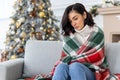 Sad lonely bored woman alone sitting on sofa at home in living room for Christmas, sad and depressed near Christmas tree Royalty Free Stock Photo